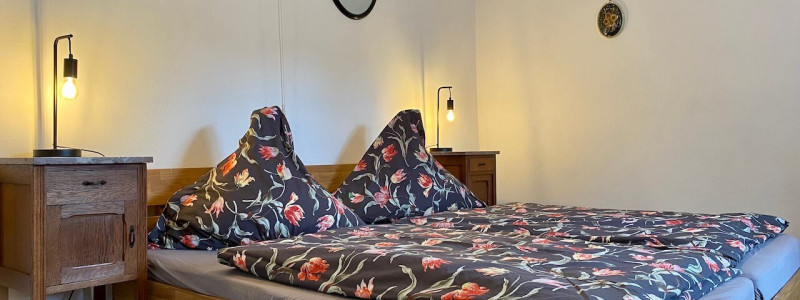 altes pfarrhaus denkmalschutz lehmputz hanf jute dämmung kalkputz sanierung mit natuerlichen baumaterialien flohmarktfunde vintage second hand recycling upcycling retro eifel nachhaltiger urlaub in der natur suedeifel luxemburg belgien mit der familie schlafzimmer