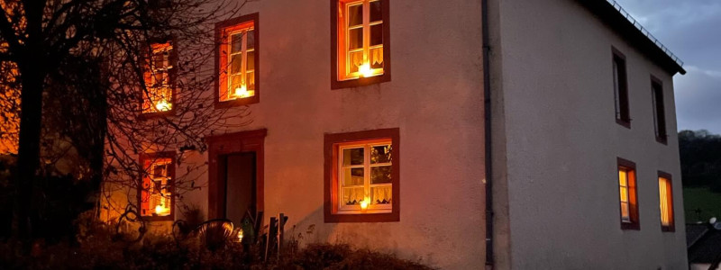 altes pfarrhaus denkmalschutz lehmputz hanf jute dämmung kalkputz sanierung mit natuerlichen baumaterialien flohmarktfunde vintage second hand recycling upcycling retro eifel nachhaltiger urlaub in der natur suedeifel luxemburg belgien mit der familie haus aussenansicht schraeg von der seite bei nacht