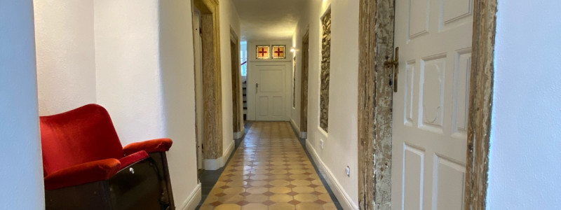 altes pfarrhaus denkmalschutz lehmputz hanf jute dämmung kalkputz sanierung mit natuerlichen baumaterialien flohmarktfunde vintage second hand recycling upcycling retro eifel nachhaltiger urlaub in der natur suedeifel luxemburg belgien mit der familie flur mit kinosessel