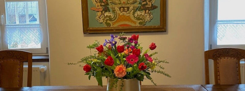 altes pfarrhaus denkmalschutz lehmputz hanf jute dämmung kalkputz sanierung mit natuerlichen baumaterialien flohmarktfunde vintage second hand recycling upcycling retro eifel nachhaltiger urlaub in der natur suedeifel luxemburg belgien mit der familie esstisch blumen