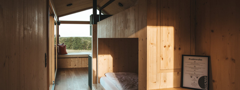 auszeit tollensesee mecklenburger seenplatte mecklenburg-vorpommern neubrandenburg energieneutral energiepositiv minimalhäuser tiny houses plastikvermeidung geringer co-2-fussabdruck holz ökologische bauweise photovoltaik urlaub mit kindern mit hund am wasser entspannung ruhe einsamkeit bett