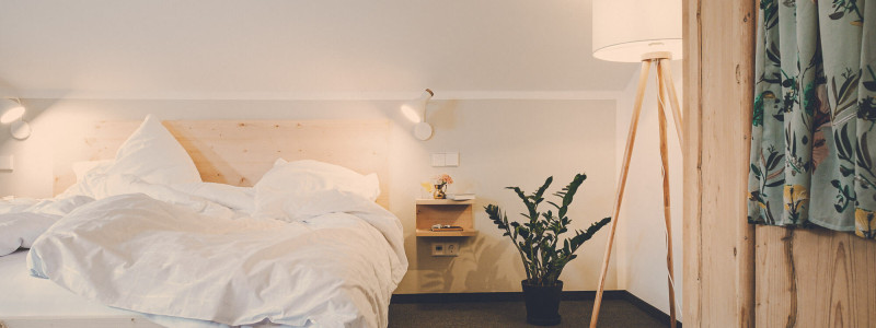 lederer hof tegernsee boutique apartments urlaub am wasser in den bergen mit kindern mit hund regionales fruehstueck kurze transportwege lokale lieferanten second hand moebel holzmoebel schlafzimmer bett detail