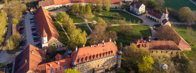 nachhaltige unterkuenfte in deutschland urlaub auf dem land in der natur gemeinwohlprinzip solidarische landwirtschaft hotel schloss blumenthal gruppen seminare blick von oben auf gebaeudeensemble