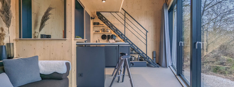 neugrad ferienhaeuser eifel naturnah ruhig nachhaltige bauweise urlaubsarchitektur holzhaeuser aussergewoehnliche architektur urlaub im gruenen auszeit zeit lassen leben spueren neu denken zwei-personen-cabin nature innenraum sofa couchtisch kueche