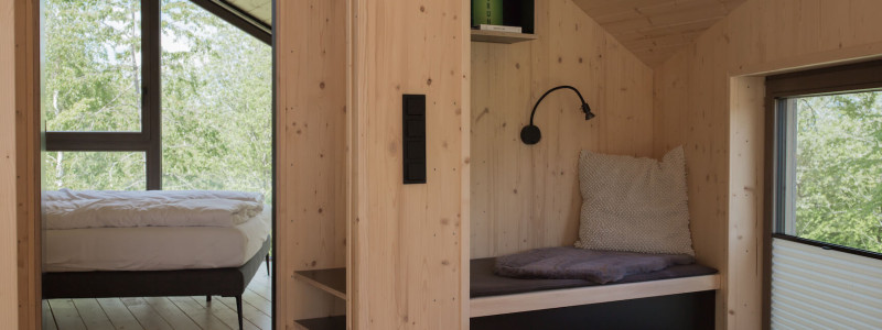 neugrad ferienhaeuser eifel naturnah ruhig nachhaltige bauweise urlaubsarchitektur holzhaeuser aussergewoehnliche architektur urlaub im gruenen auszeit zeit lassen leben spueren neu denken schlafzimmer sitznische obergeschoss im vier personen haus