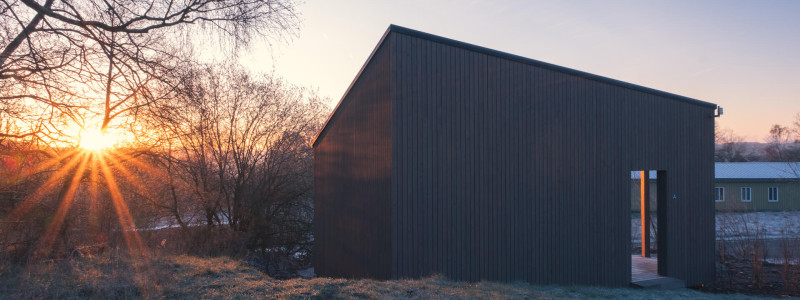 neugrad ferienhaeuser eifel naturnah ruhig nachhaltige bauweise urlaubsarchitektur holzhaeuser aussergewoehnliche architektur urlaub im gruenen auszeit zeit lassen leben spueren neu denken zwei-personen-cabin nature aussenansicht sonnenaufgang