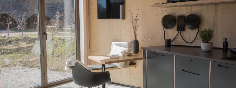 neugrad ferienhaeuser eifel naturnah ruhig nachhaltige bauweise urlaubsarchitektur holzhaeuser aussergewoehnliche architektur urlaub im gruenen auszeit zeit lassen leben spueren neu denken kueche sitzplatz im zwei personen haus