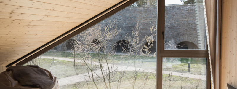 neugrad ferienhaeuser eifel naturnah ruhig nachhaltige bauweise urlaubsarchitektur holzhaeuser aussergewoehnliche architektur urlaub im gruenen auszeit zeit lassen leben spueren neu denken zwei-personen-einheit im doppelhaus blick vom schlafbereich auf die kasematten