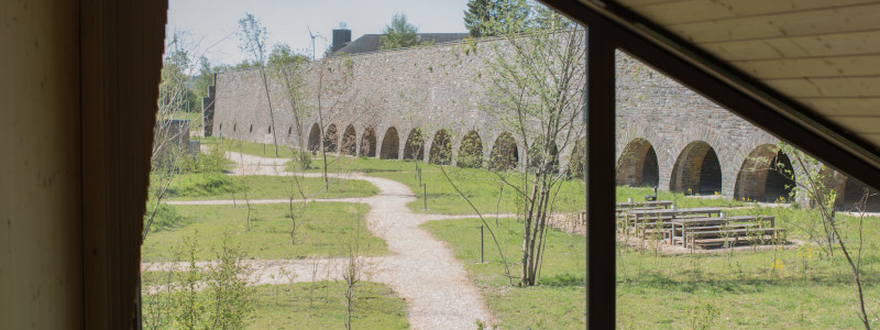 neugrad ferienhaeuser eifel naturnah ruhig nachhaltige bauweise urlaubsarchitektur holzhaeuser aussergewoehnliche architektur urlaub im gruenen auszeit zeit lassen leben spueren neu denken blick auf die natursteinmauer