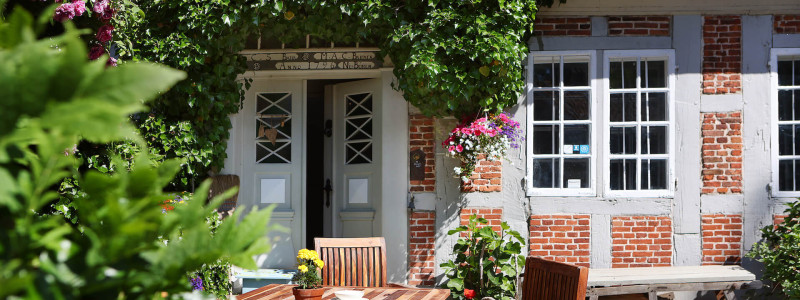 ort der zeit stentenmuehle schleswig holstein ferienwohnungen urlaub am wasser im gruenen in der natur mit hunden zwischen zwei meeren wasserkraftwerk hauseingang weinumrankt efeu