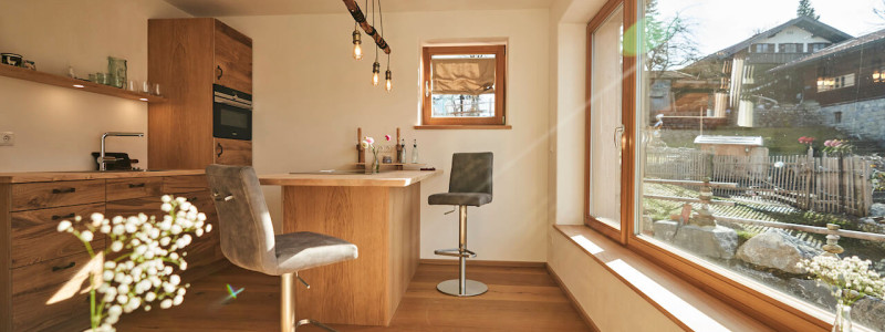 stadtalm toelzer land bad toelz urlaub in deutschland voralpenland in der natur in bayern in den bergen auf dem land im gruenen nachhaltige oekologische unterkunft holz lehm bienen lamas kubische bauweise alpinarchitektur ferienwohnung alpakaglueck kueche wohnraum blick nach draussen