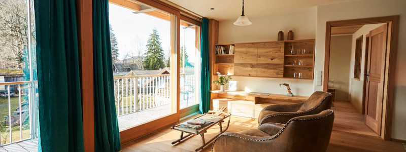 stadtalm toelzer land bad toelz urlaub in deutschland voralpenland in der natur in bayern in den bergen auf dem land im gruenen nachhaltige oekologische unterkunft holz lehm bienen lamas kubische bauweise alpinarchitektur ferienwohnung isarflimmern karwendelrauschen ledersessel alter schlitten vintage