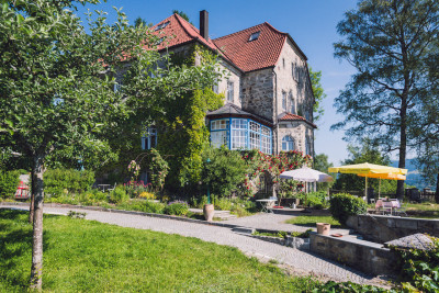 villa breitenberg bayerischer wald nachhaltige unterkunft boutiquie hotel ferienwohnung natur berge ruhe biologische kueche kultur seminare yoga retreats hochzeiten frontansicht gelber sonnenschirm
