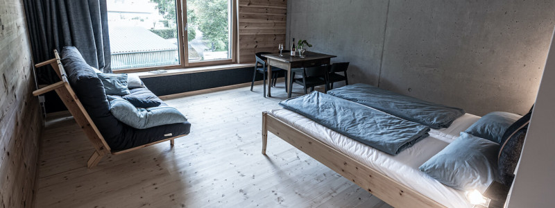 weingut idler bio appartment biologisches weingut remstal weinregion mondholz zirbenholz natuerliche materialien moderne architektur weinberge wandern radfahren kanufahren kultur weinarchitektur urlaubsarchitektur bett schlafsofa fenster tisch