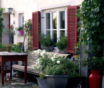 zweite heimat privatpension pension bed and breakfast urlaub in der stadt staedtereise urlaub am wasser urlaub in der natur upcycling vintage second hand historische architektur vegetarisches fruehstueck idylle wie in italien vor dem haus rote holzbank blumen